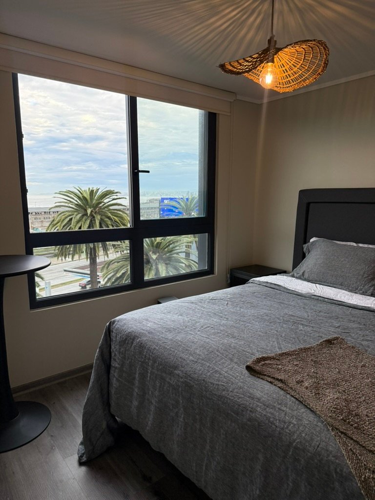 Dormitorio con cama king y vista a la bahía de Valparaíso