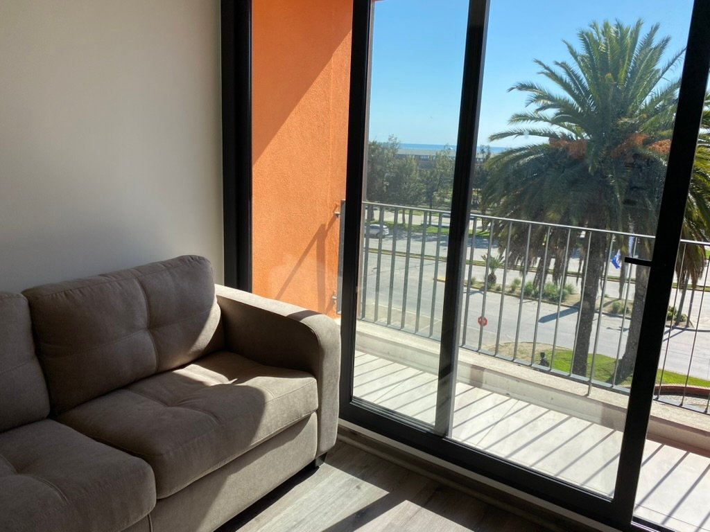 Living con acceso al balcón y vista al mar en Valparaíso