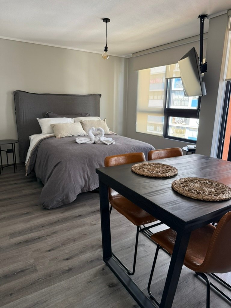 Cama y comedor de departamento tipo estudio en Valparaíso