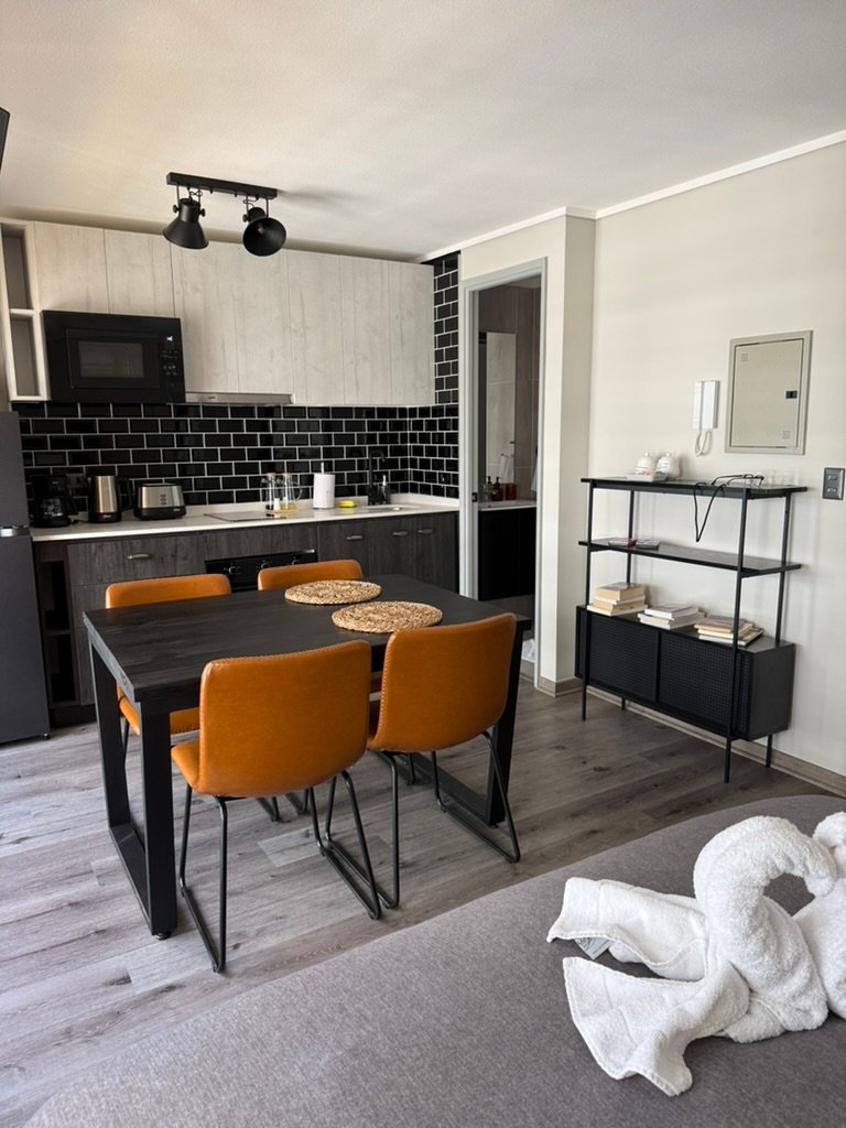 Cocina, comedor y cama de departamento tipo estudio en Valparaíso